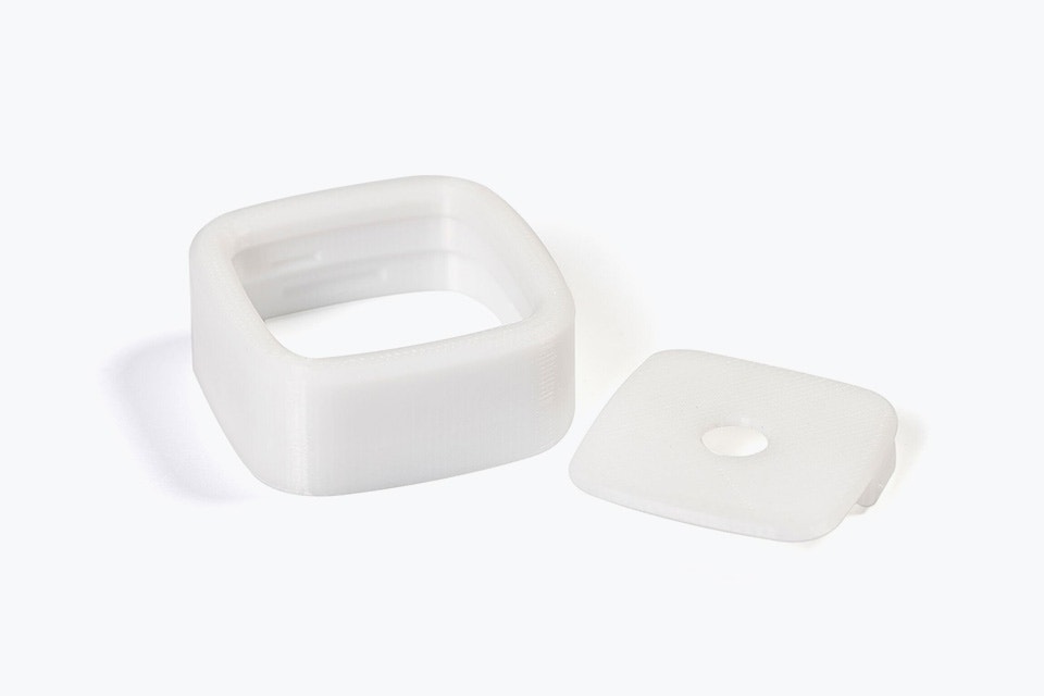 Une boîte blanche, carrée, à fond ouvert, imprimée en PC-ISO à l'aide de l'impression 3D par dépôt de fil fondu.