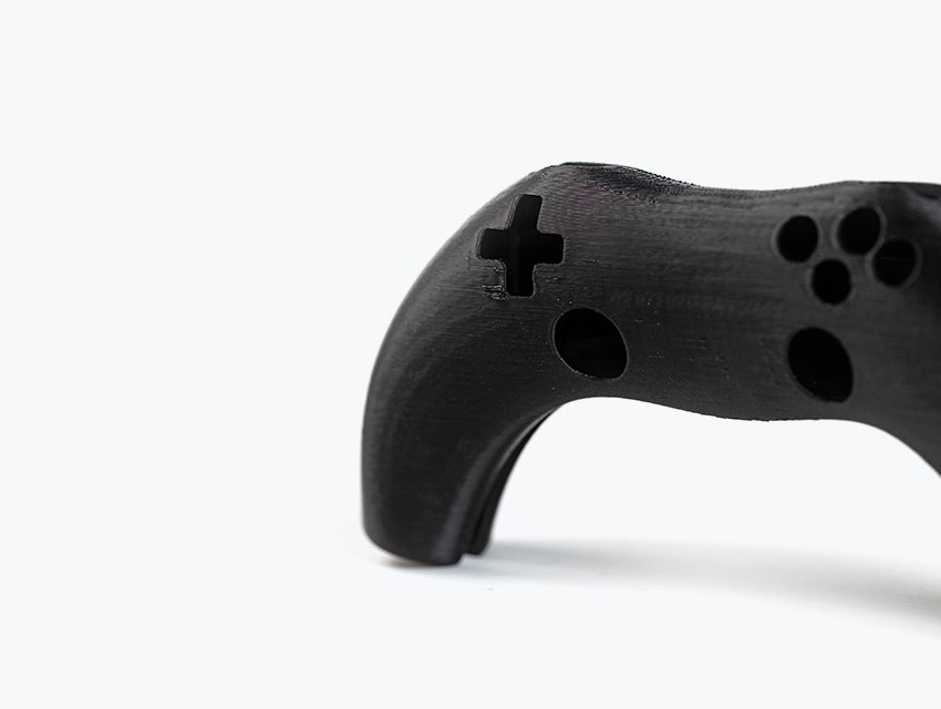 Un controller per videogiochi nero stampato in 3D stampato in ABS-ESD7 utilizzando la modellazione a deposizione fusa.