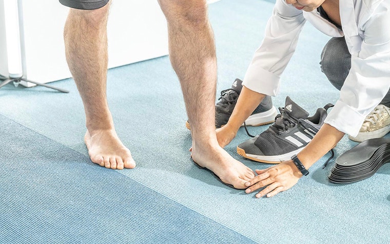 Doctor crouched down to inspect a patient's foot