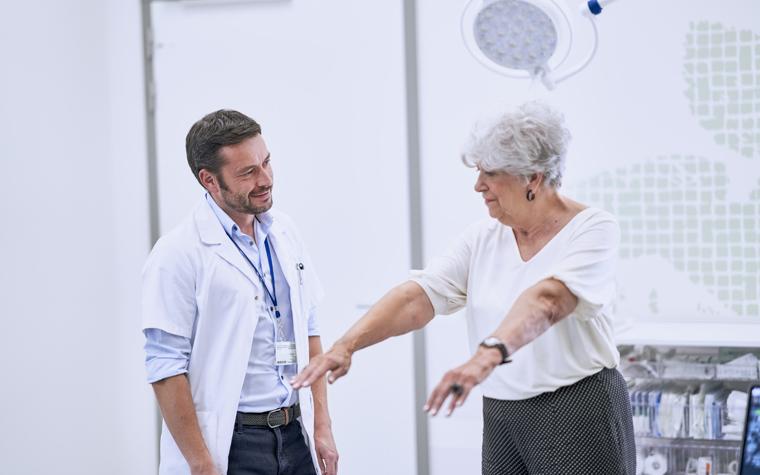 Doctor checking an elderly female patient's range of motion in her shoulders