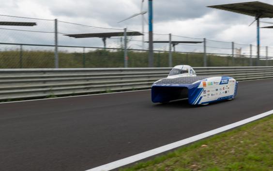 Person driving the solar car on the road