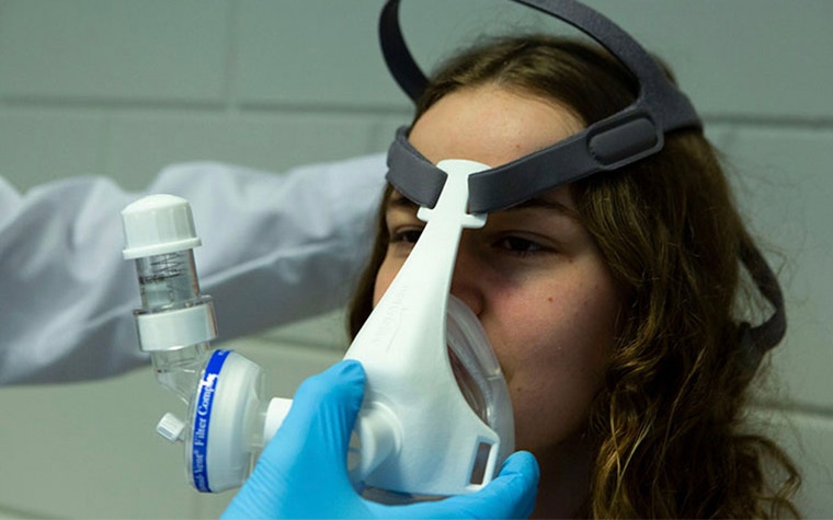 Person applying a NIP mask with 3D-printed components to a patient