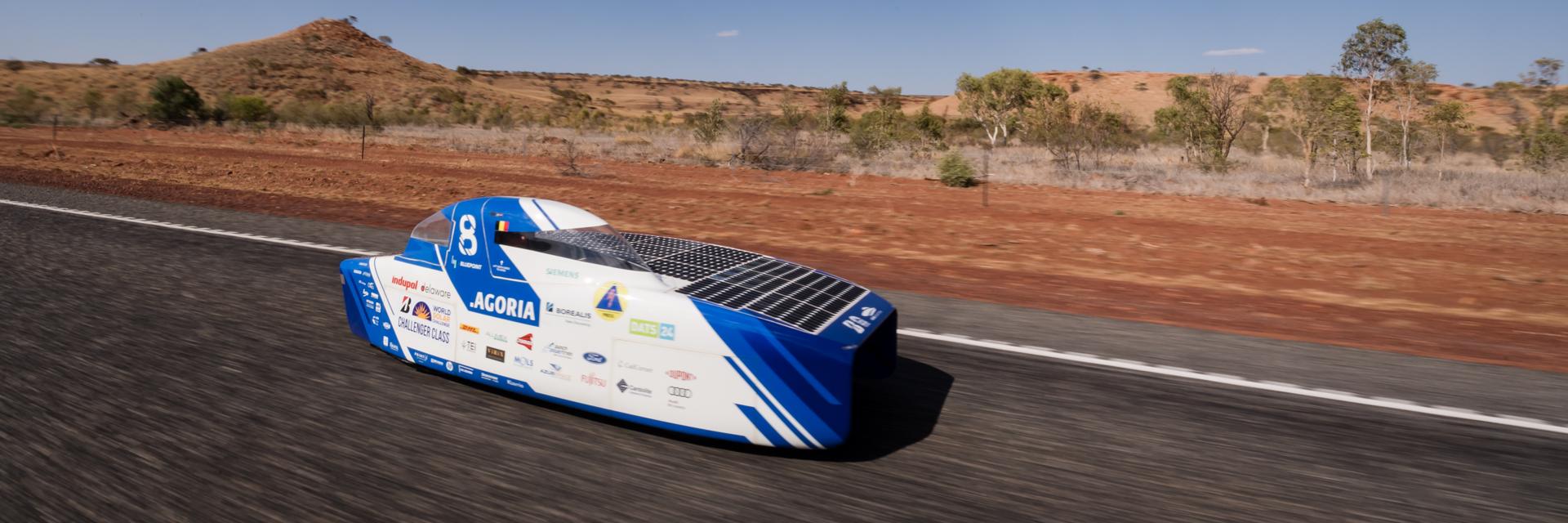 Solar car driving along a road in the Australian outback
