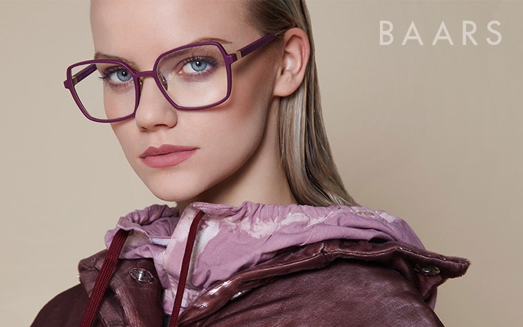 Modella che guarda nella fotocamera e indossa occhiali viola della collezione BAARS Selasi