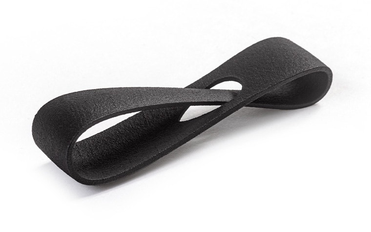 Eine schwarze 3D-gedruckte Schlaufe aus PA 11, die mit Multi-Jet-Fusion hergestellt wurde, eingefärbt + Spritzlack-Finish.