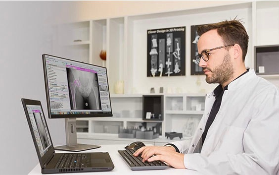 Man using 3D planning medical software in a lab coat