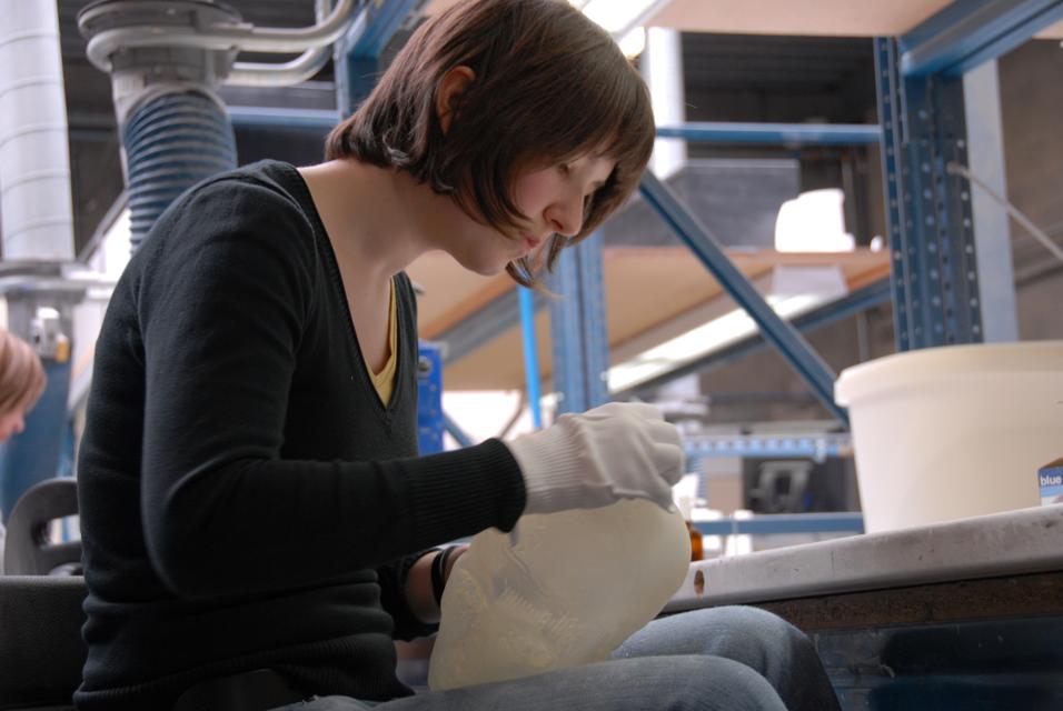 Woman finishing a 3D-printed model in Materialise's production area