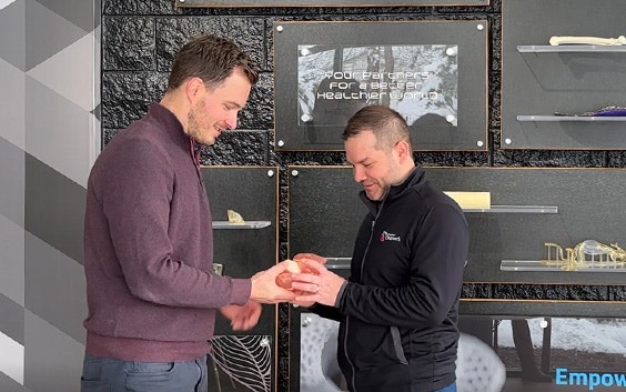 Dr. Ryan Moore looking at a 3D-printed heart model in the Materialise office with a colleague from Materialise