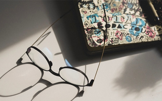 Eyeglasses on a design with a shadow extending from them
