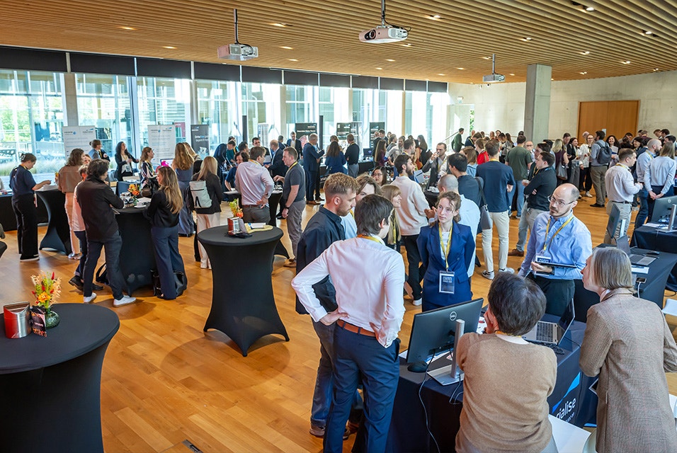 A large hall at the 3D Plannign and Prining in Hospitals Forum 2026, with attendees gathered at standing tables to have discussions or at booths to learn more about products.