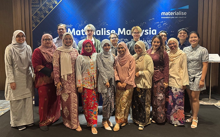 A large group of people standing in front of a wall-hanging banner with the text "Materialise Malaysia"