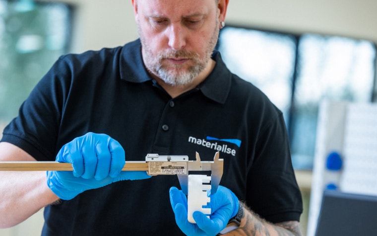 Materialise production team member measuring a 3D-printed part