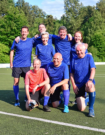 Materialise HQ management's soccer team smiling on the field