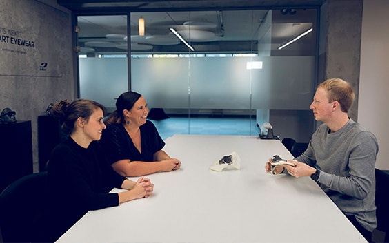 Three Materialise colleagues sitting at a table and discussing 3D-printed medical parts