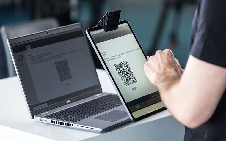 A man uses SAM to scan a QR code using an iPad featuring the SAM Mirror attachment.