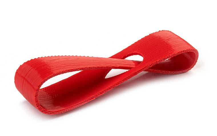 A red 3D-printed loop made from ABS-M30 using fused deposition modeling, with a normal finish.