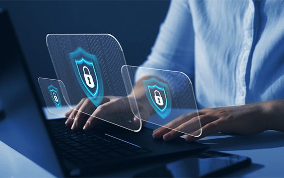 Person with their hands on a laptop and graphics of secure locks floating in front of the computer
