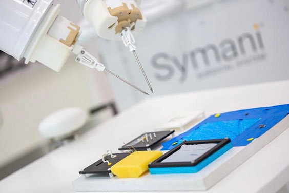 Symani Surgical System robotic arms and the original square training board for practicing microsurgeries