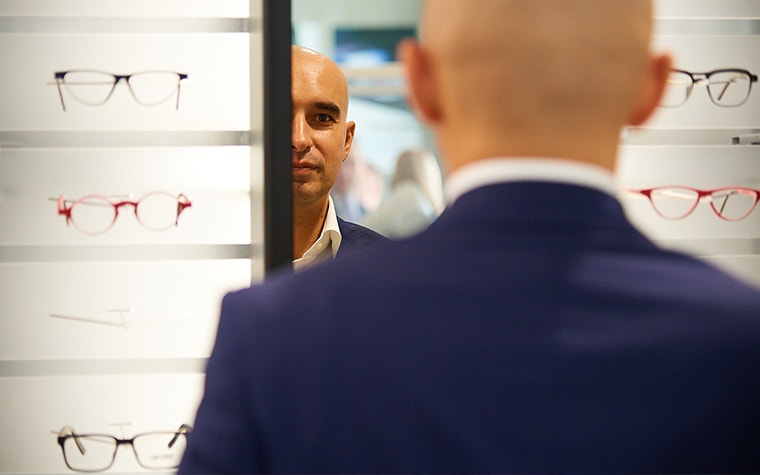 Ein Mann steht vor einem Yuniku 3D-Scanner in einem Brillengeschäft
