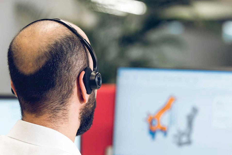 View over the shoulder of a man using Magics with a headset on