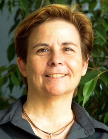 A portrait image of Dr. Victoria Melhuish against a leafy backdrop.