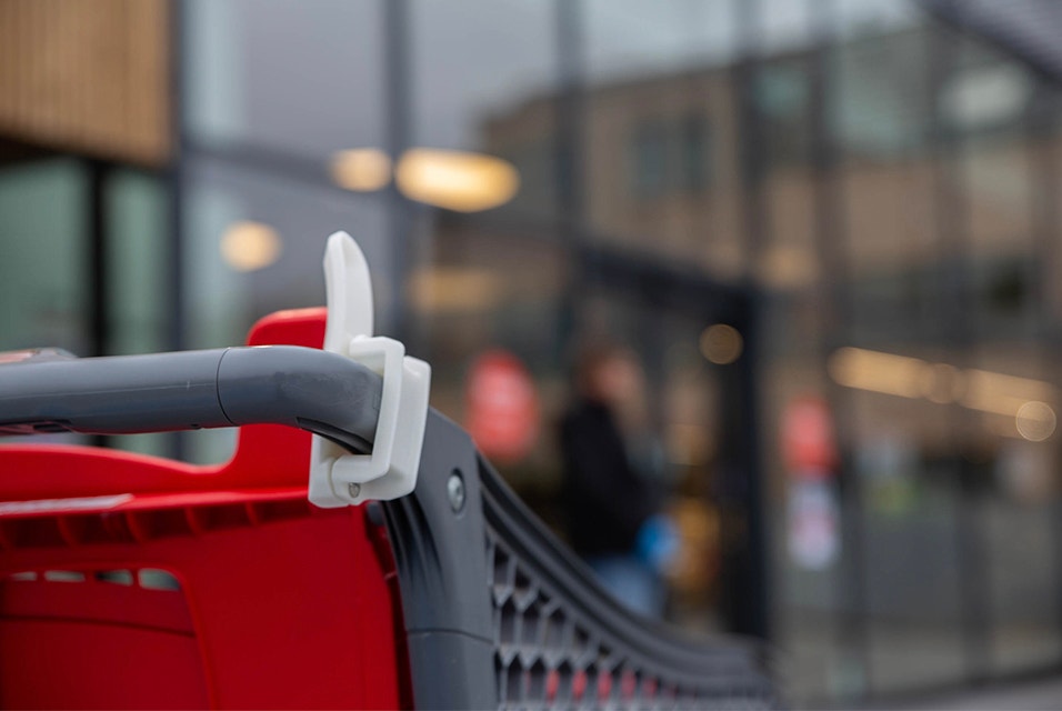 Hands-free shopping cart handles attached to a shopping cart outside of a store