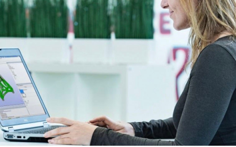 Woman sitting a desk using a laptop with Magics on it