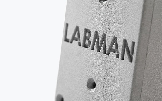 Bloque impreso en 3D en PA-AF con la palabra "LABMAN" grabada