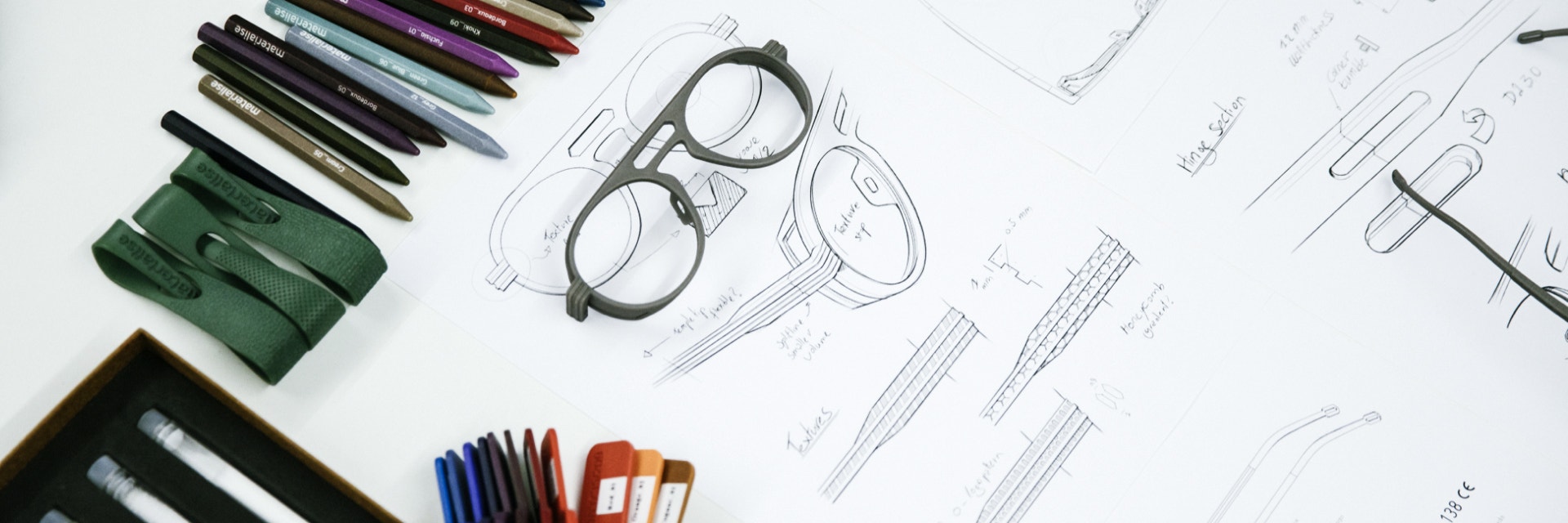 3D-gedruckte Brillen und Muster auf einem mit Bunt- und Kugelschreibern gezeichneten Entwurf