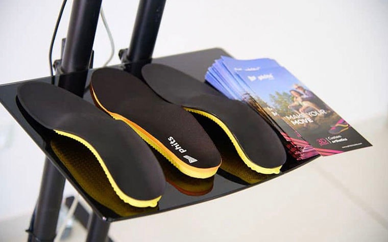 3D-printed phits orthotics on a table next to phits brochures