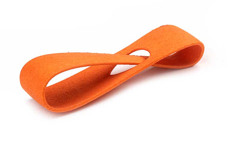 Un bucle de muestra liso impreso en 3D en PA-GF y teñido en naranja.