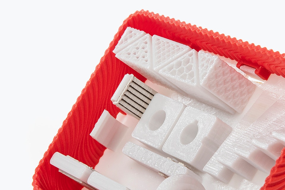 Vue rapprochée inclinée de l'intérieur d'une pièce rouge et blanche imprimée dans le matériau ABS-M30 avec FDM