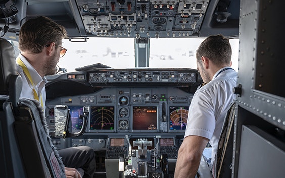 Two pilots sitting in the cockpit of an aircraft