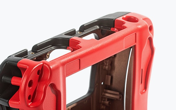 Primo piano di una parte rossa e nera di un rilevatore di crepe portatile, colato sottovuoto utilizzando il materiale poliuretanico simile all'ABS