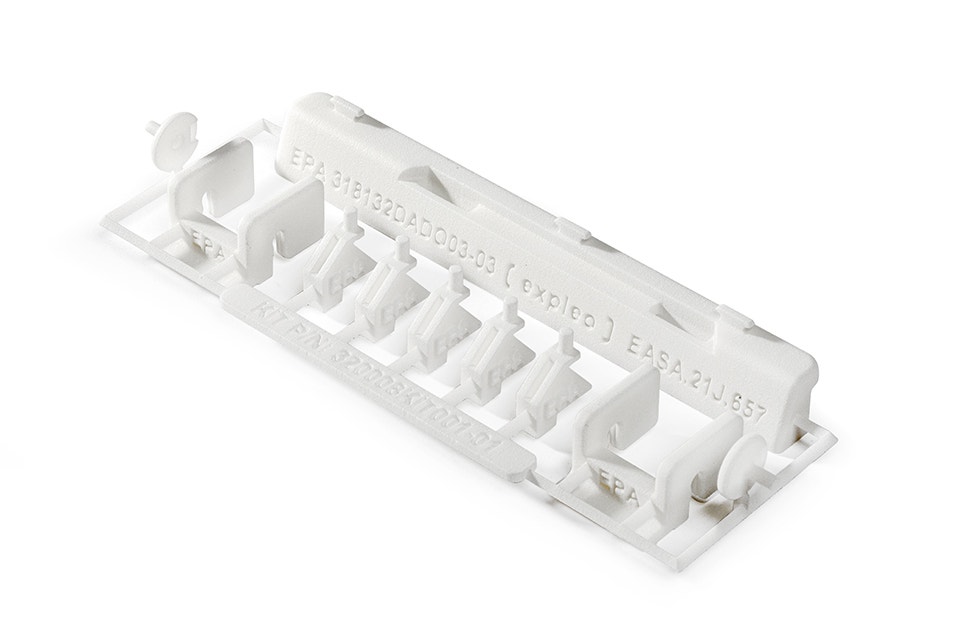 Una serie de kits de reparación impresos en 3D, pequeñas piezas de plástico blanco de poliamida retardante de llama diseñadas por Expleo. Estas piezas se utilizan para sustituir cierres que suelen romperse en los paneles del Boeing 737.