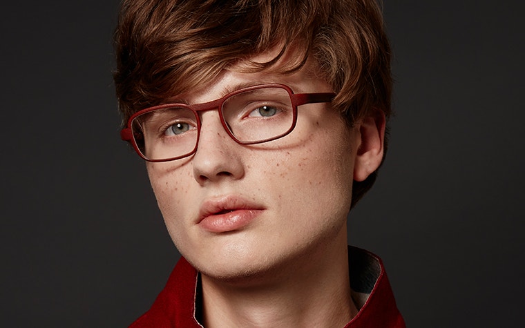 Model looking into the camera, wearing red eyeglasses from the Hoet Cabrio PZ collection