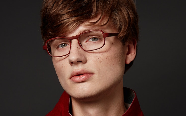 Model looking into the camera, wearing red eyeglasses from the Hoet Cabrio PZ collection