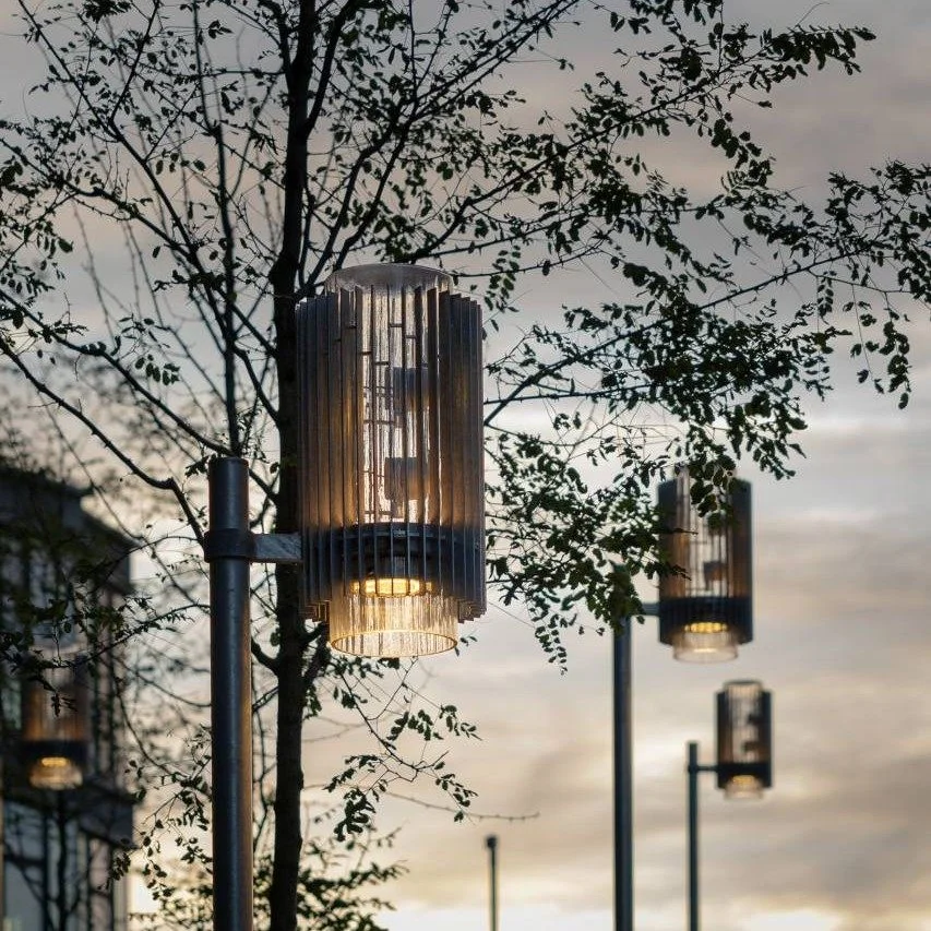 Four modern street lamps shining at dusk