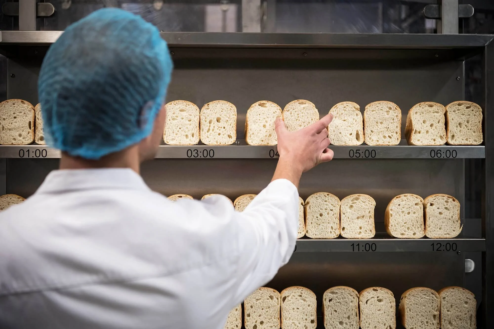 Employee in the laboratory performing pressure test on baked goods in the shelf