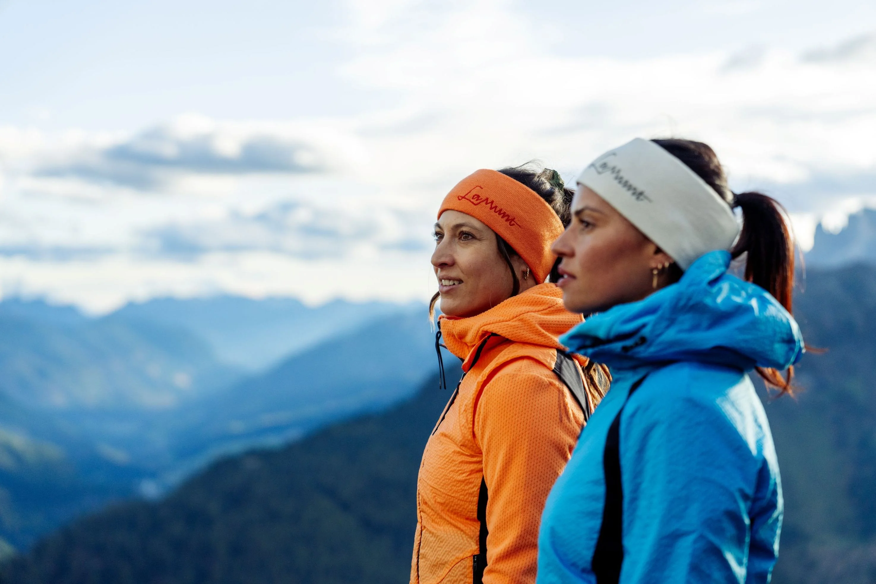Frau mit sportivem Stirnband von Lamunt der Oberalp Gruppe und funktioneller Jacke bei Panorama-Wanderung in den Dolomiten