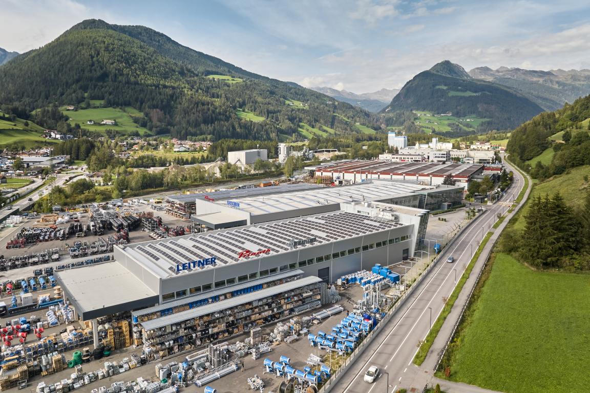Large company site with spacious factory halls surrounded by green landscape