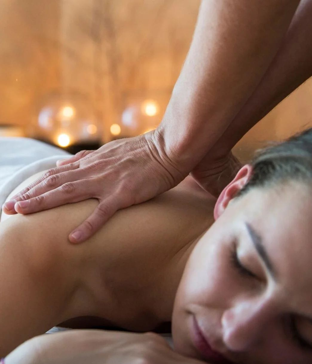 Hands gently massaging the back of a woman