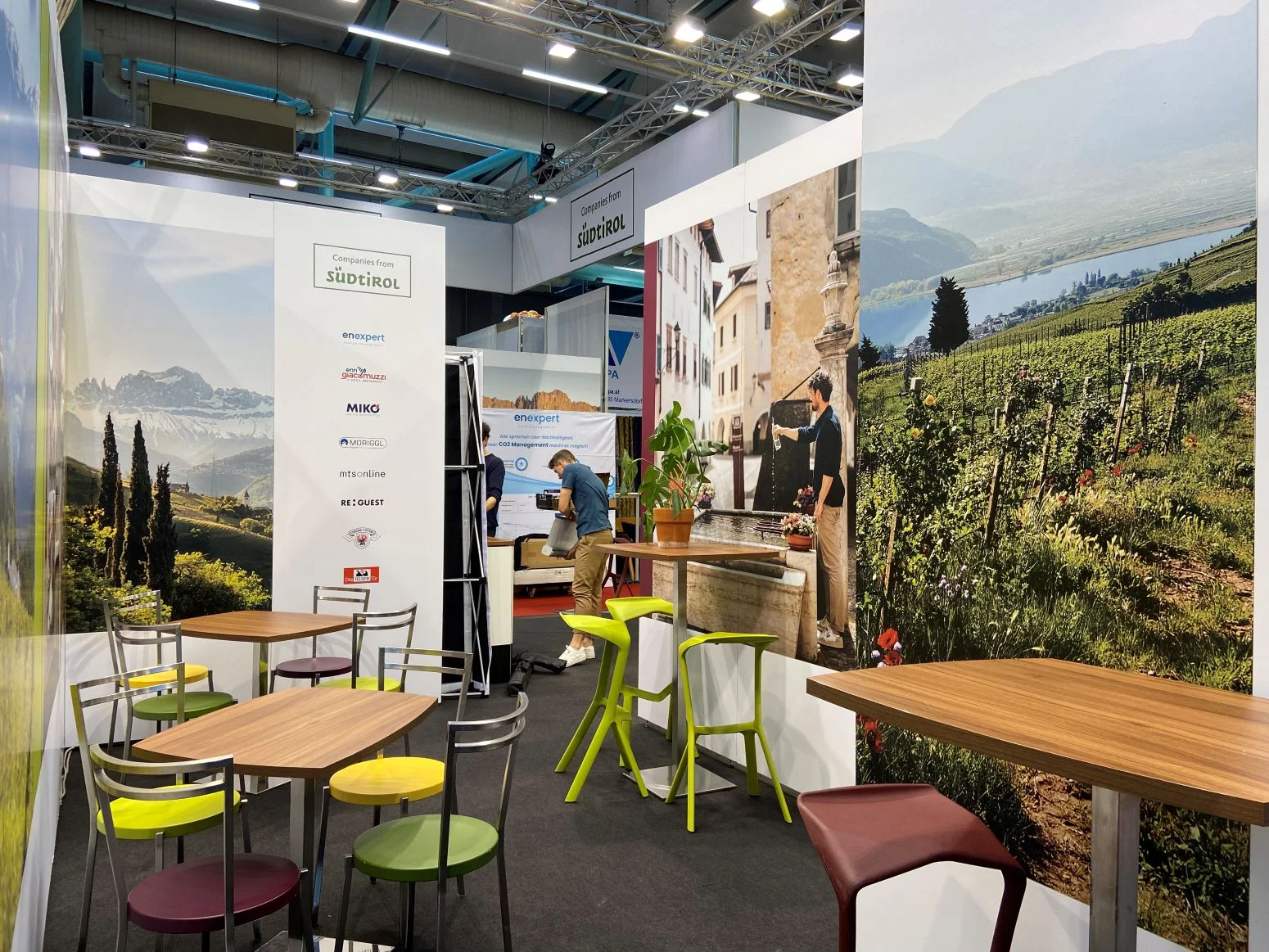 A visitor area at the trade fair booth decorated with photos of South Tyrol