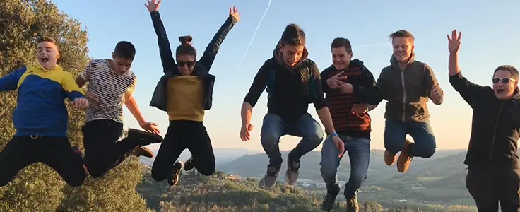 Schüler und Lehrer springen vor einer traumhaften Kulisse in die Luft. Schüler und Lehrer springen vor einer traumhaften Kulisse in die Luft.