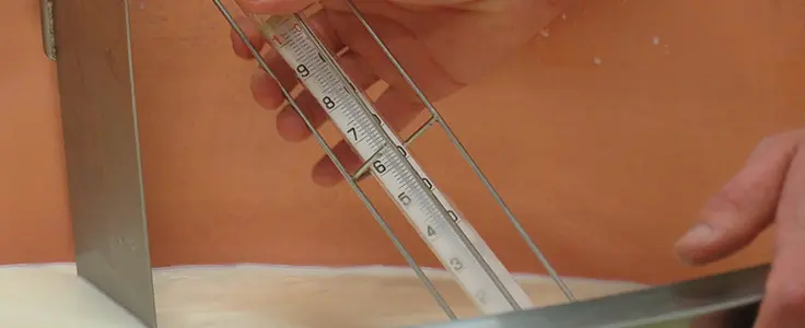 Thermometer misst die Milchtemperatur Thermometer misst die Milchtemperatur