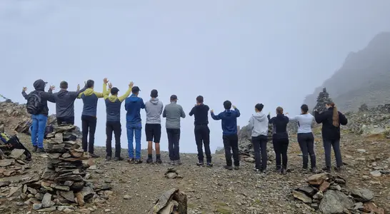 Schüler stehen mit armen in der Luft am Grat. Schüler stehen mit armen in der Luft am Grat.