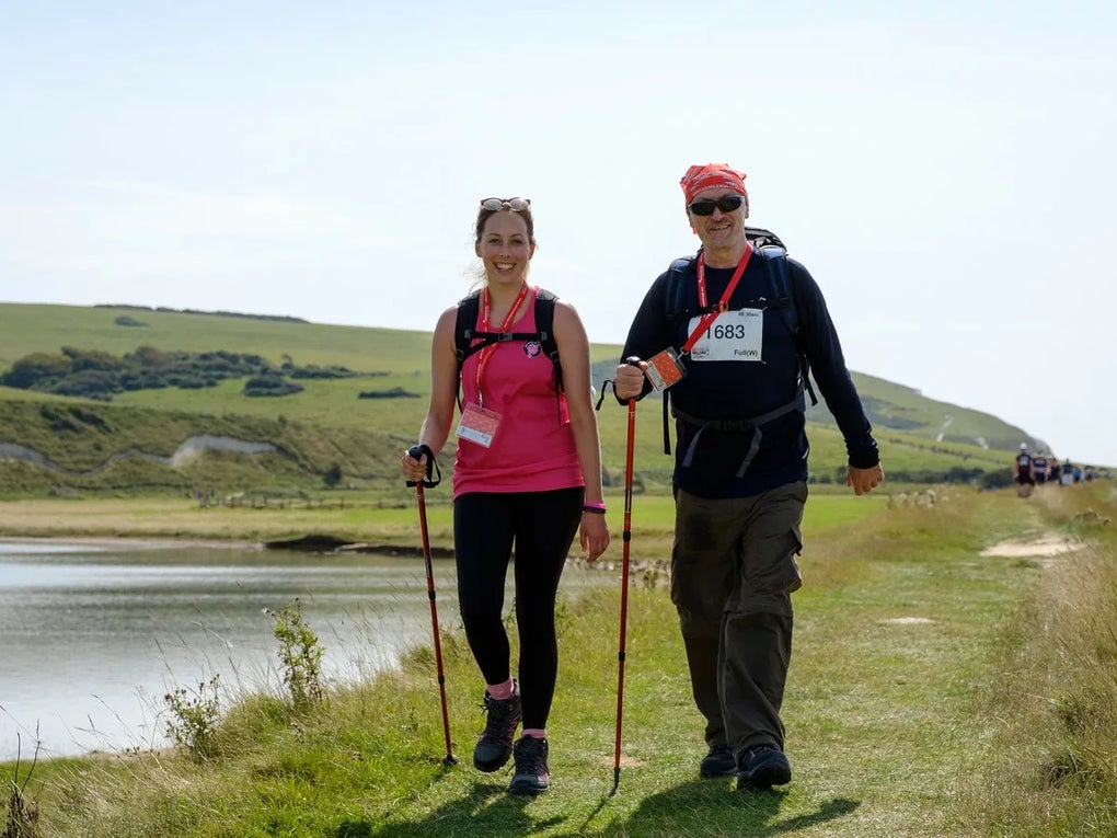 A man and a woman walking next to a lake A man and a woman walking next to a lake