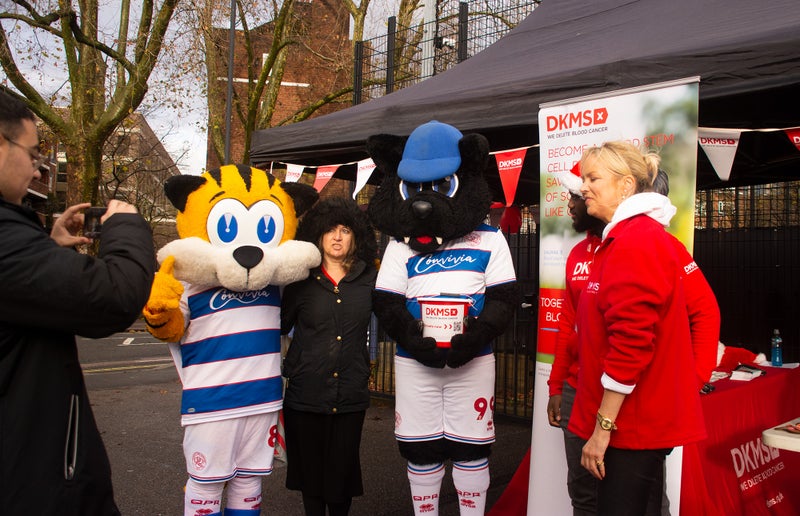 DKMS Staff and volunteer having their photo taken with the QPR mascots Spark the Tiger and Jude the Cat  