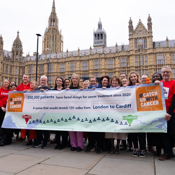 Participant at the catch up with cancer event smiling and holding up a banner Participant at the catch up with cancer event smiling and holding up a banner