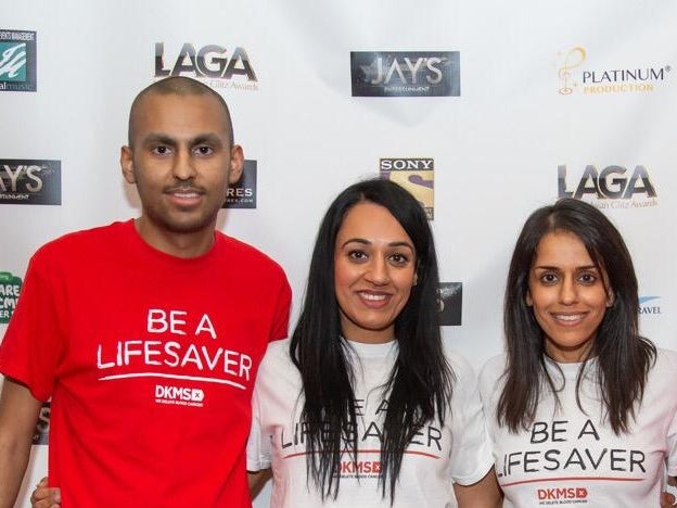 Four DKMS volunteers wearing branded t-shirts in front of a banner Four DKMS volunteers wearing branded t-shirts in front of a banner